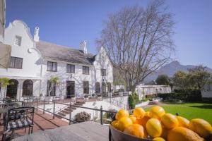 a bowl of oranges sitting on a table in front of a house at The Andros Boutique Hotel in Cape Town