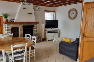 a living room with a table and a fireplace at Une petite maison du Rozel - gite tout confort in Le Rozel