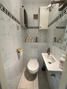 a white bathroom with a toilet and a sink at Charming Apartment direct access beach Blankenberge in Blankenberge