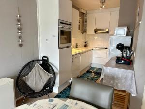 eine kleine Küche mit einem Tisch und einem Stuhl darin in der Unterkunft Charming Apartment direct access beach Blankenberge in Blankenberge
