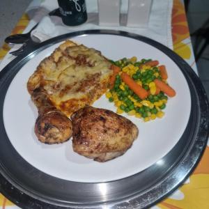 um prato de alimentos com carne e legumes sobre uma mesa em Badi's B&B Guest house em Middledrift