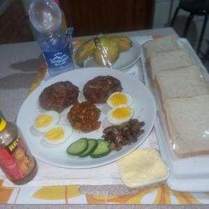 um prato de ovos e pickles e pão numa mesa em Badi's B&B Guest house em Middledrift