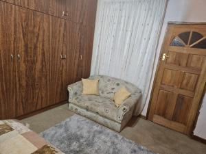 um quarto com um sofá, uma porta e uma janela em Badi's B&B Guest house em Middledrift
