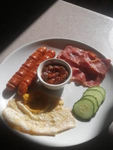 um prato de comida de pequeno-almoço com salsicha e outros alimentos em Badi's B&B Guest house em Middledrift