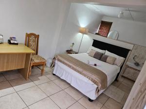 a bedroom with a large bed and a desk and a desk at Badi's B&B Guest house in Middledrift