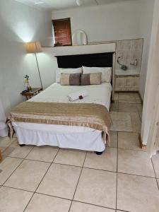 um quarto com uma cama e piso em azulejo em Badi's B&B Guest house em Middledrift