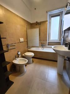 uma casa de banho com 2 lavatórios, um WC e uma banheira em Tia Tourist Apartment Rome em Roma