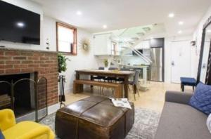 a living room with a couch and a fireplace at Beautifully Designed 3 BR Apartment in New York