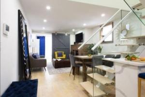 a living room and kitchen with a staircase in a house at Beautifully Designed 3 BR Apartment in New York