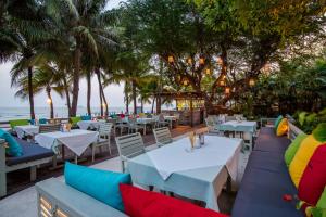 a restaurant on the beach with tables and chairs at Anantasila Beach Resort Hua Hin in Hua Hin