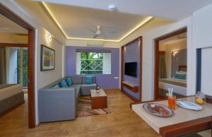 a living room with a couch and a tv at Noah Sky Suites in Cochin