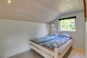 Bett in einem kleinen Zimmer mit Fenster in der Unterkunft Holiday Home In Quiet Neighborhood in Hals