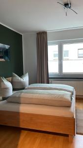 1 dormitorio con cama y ventana grande en haustierfreundliche Ferienwohnung Greifenbach en Geyer