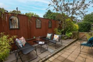 a patio with chairs and a table and a fence at Owl Cottage in Morpeth