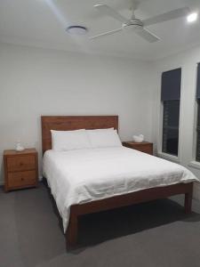 a bedroom with a large white bed and two windows at JervisBayStays TheSanctuaryFour in Sanctuary Point