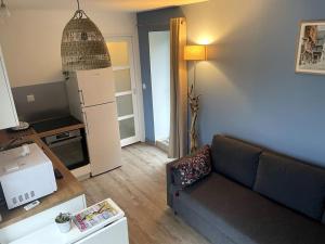ein Wohnzimmer mit einem Sofa und einer Küche in der Unterkunft la halte des marais in Huismes