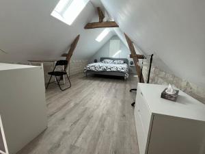 ein Schlafzimmer mit einem Bett und einem Schreibtisch im Dachgeschoss in der Unterkunft la halte des marais in Huismes
