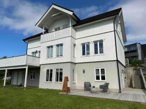 a large white house with two chairs in front of it at Warm and lovely apartment with free parking in Tromsø