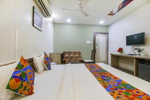 Una habitación con una cama con una manta de colores. en FabHotel Smriti Star en Bhopal