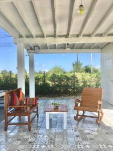 a porch with two chairs and a coffee table at Huen Chaivaree in Nan