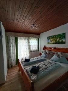 a bedroom with two beds and a wooden ceiling at Haus Alexander in Fresach