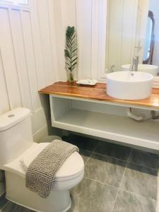 a bathroom with a white toilet and a sink at Huen Chaivaree in Nan