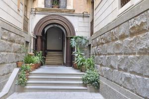 un ingresso a un edificio con scale e piante in vaso di Liodoro Catania B&B a Catania