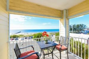 balcón con mesa, sillas y vistas al océano en 102 6Th St S- Upstairs Home, en Bradenton Beach