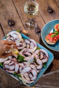 a plate of mushrooms and a glass of wine on a table at Gili Asahan Eco Lodge & Restaurant in Gili Asahan