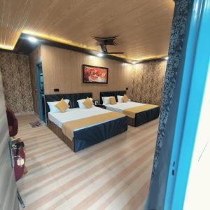 a hotel room with two beds and a ceiling at Hotel Pearl Residency in Mukteshwar