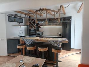 una cucina con ampia isola e sgabelli da bar di Luxury Larch Loft a Tesido