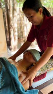 une femme donne à une femme un massage du dos dans l'établissement Gili Asahan Eco Lodge & Restaurant, à Gili Asahan