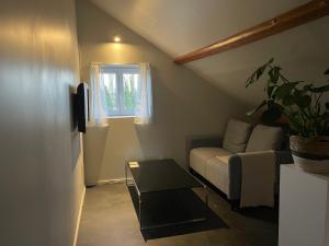 uma sala de estar com um sofá e uma janela em Belle vue em Saint-Silvain-Bas-le-Roc