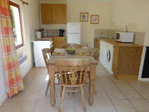 cocina con mesa, sillas y mesa en Daisy Cottage with seasonal Swimming Pool, en Le Mesnil-Gilbert