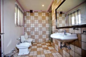 bagno con 2 servizi igienici, lavandino e specchio di The GoodFind Residency a Srinagar