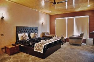 a bedroom with a bed and a chair in it at The GoodFind Residency in Srinagar