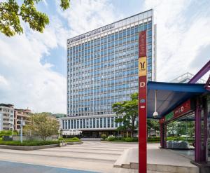 広州市にあるArthur Hotel Luogang Xiangang Metro Guangzhou-Free Breakfast and Free Afternoon Teaの前に看板がある高い建物