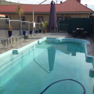 a swimming pool with a pool table and chairs at Poet's Recall Motel in Gundagai