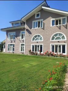 a large house with a lawn in front of it at The GoodFind Residency in Srinagar