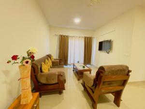 a living room with a couch and chairs and a tv at ALanKrita Homes in Lucknow
