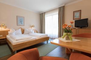 a hotel room with a bed and a table at Landhotel Häuserl im Wald in Gröbming +106 photos