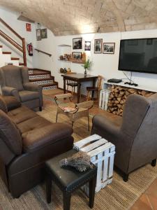 a living room with couches and a flat screen tv at L'Olivera Casa Rural in Castellbisbal