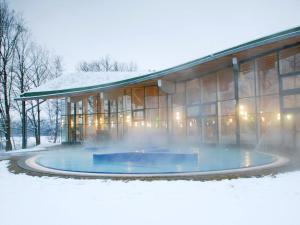 ein Gebäude mit einem Brunnen davor im Schnee in der Unterkunft Beautiful tiny house in the Waldviertel in Vitis