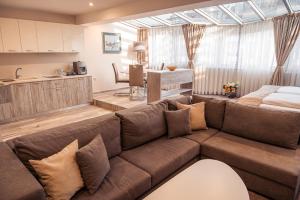 un soggiorno con divano marrone e una cucina di Cityscape Luxury Suites a Plovdiv