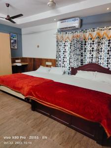 una camera da letto con un grande letto con una coperta rossa di Sunshine Service Villa a Kannur
