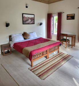 1 dormitorio con 1 cama grande con manta roja en Majkhali Woods, Ranikhet, By Himalayan Eco Lodges en Rānīkhet