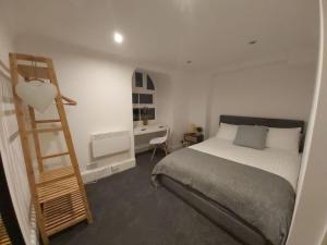 een slaapkamer met een bed en een houten ladder bij The Cozy Landport Loft in Portsmouth