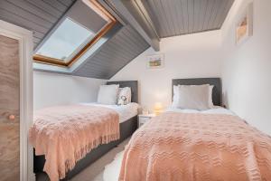 een slaapkamer op zolder met 2 bedden en een raam bij The Waterfall Retreat in Penrith