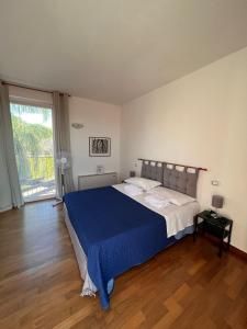 a bedroom with a large bed with a blue blanket at Villa delle Gazanie -Camera in villa -Vista panoramica sul Golfo in Quartu SantʼElena