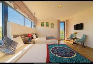 um quarto de hotel com duas camas e uma televisão em HA Gateway Inn Hoian Pool Villa em Hoi An